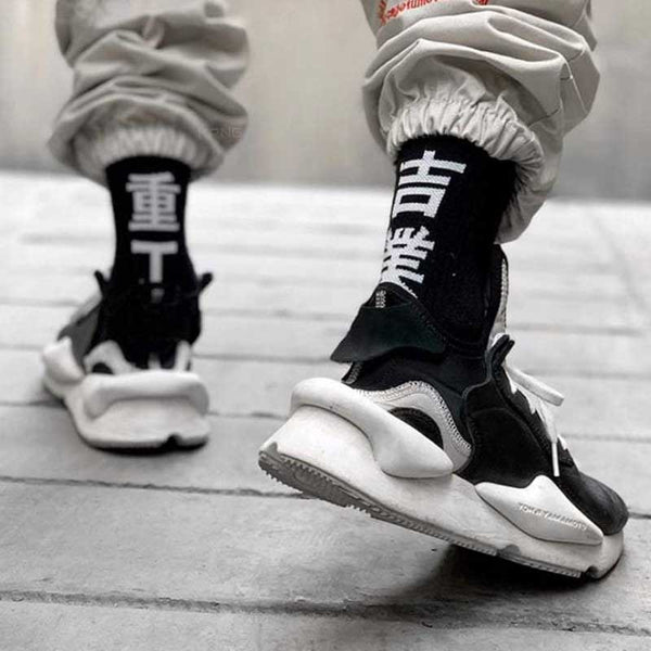 Man wearing kanji socks with black sneakers