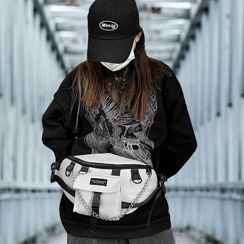 Woman wearing a white sling bag techwear with a black cap and a black hoodie