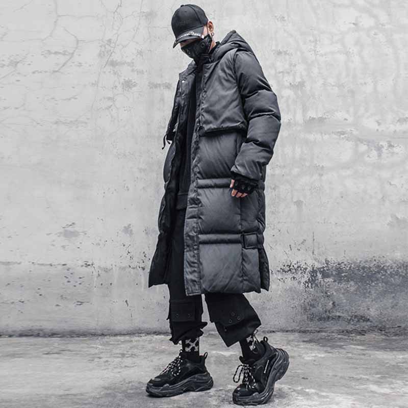 Man wearing winter jacket techwear with black trendy sneakers, tactical gloves and a black techwear cap